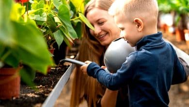 Une femme en train d'arroser avec son enfant