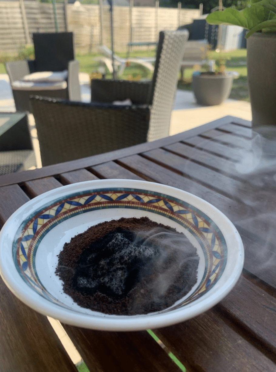 Marc de café qui brule dans le jardin pour éloigner les insectes