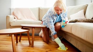 Femme nettoyant le sol de son salon