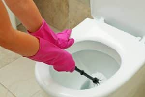 Femme en train de nettoyer sa cuvette de toilettes