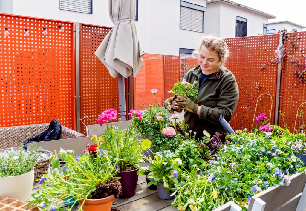 Femme avec des fleurs au balcon