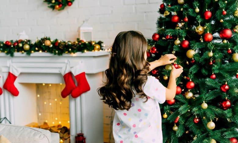 Petite fille décorant le sapin.