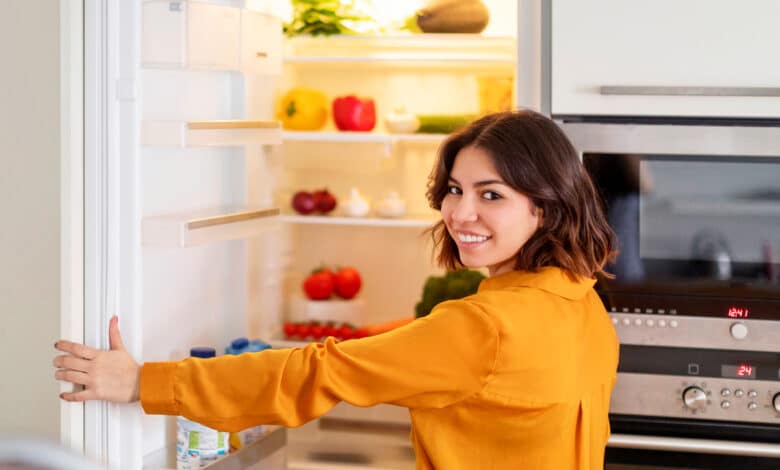 Femme ouvrant le réfrigérateur.