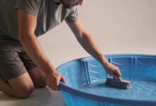 Homme agenouille nettoyant piscine gonflable bleue familiale