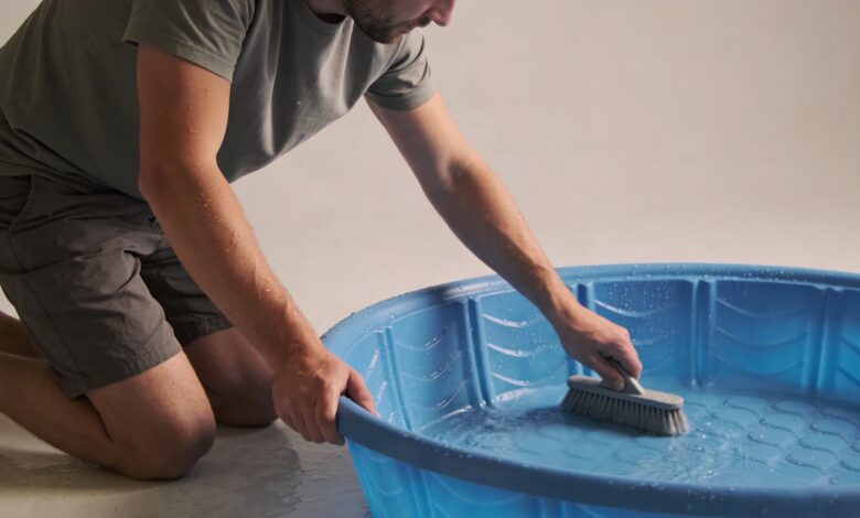Homme agenouille nettoyant piscine gonflable bleue familiale