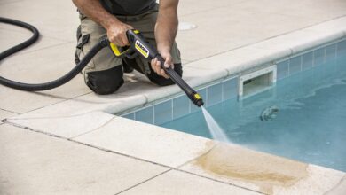 Homme agenouille nettoyant margelle de piscine au karcher