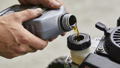 mains versant huile moteur dans petite tondeuse
