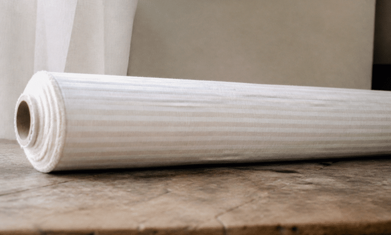 Rouleau de tissu blanc rayé posé horizontalement