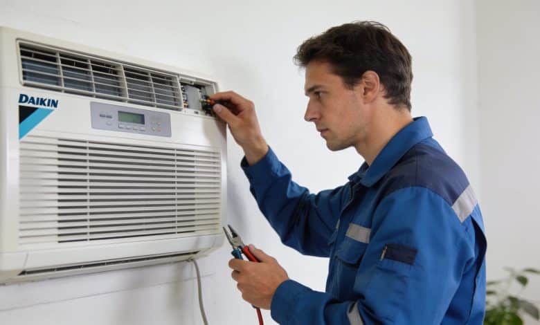 Technicien inspectant une unite climatiseur Daikin murale