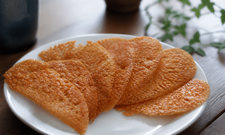 Tuiles croquantes dorées disposées en eventail sur assiette blanche.