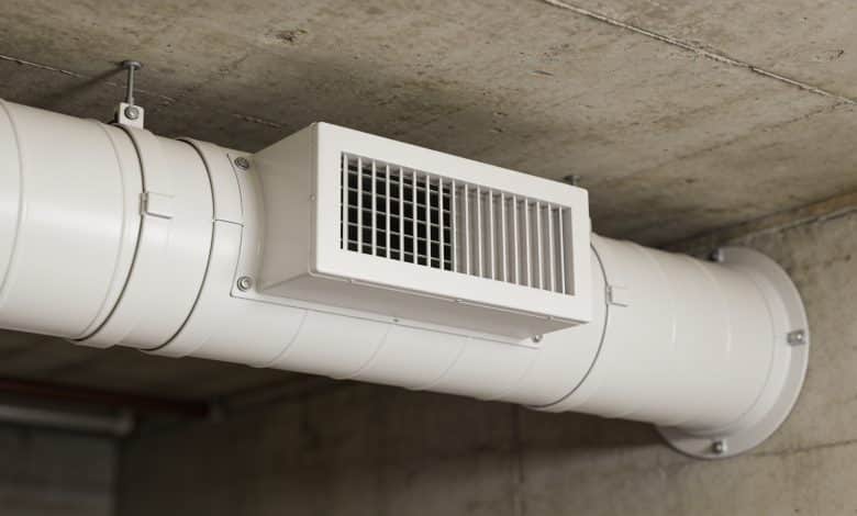 Conduit de ventilation blanc installé au plafond souterrain.