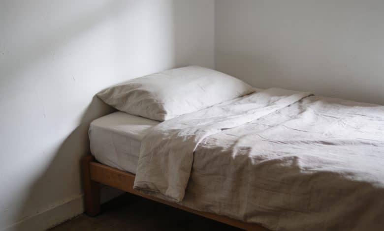 Petite chambre avec lit simple contre mur blanc