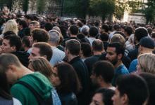 Foule dense de personnes debout cote a cote dans rue urbaine