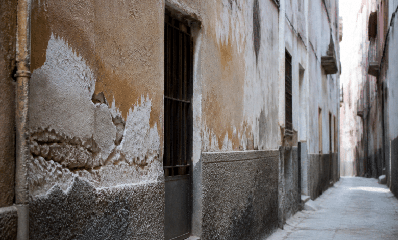 Rue urbaine étroite avec immeubles dégradés et façades abîmées