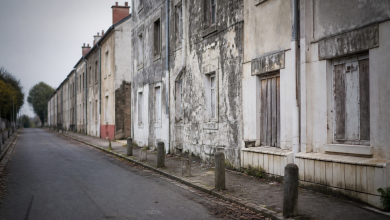 Facades d'immeubles delabres dans rue deserte de banlieue