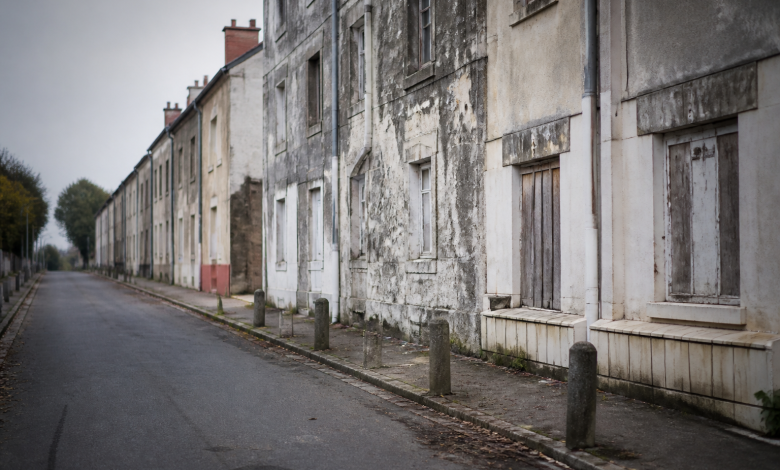 Facades d'immeubles delabres dans rue deserte de banlieue