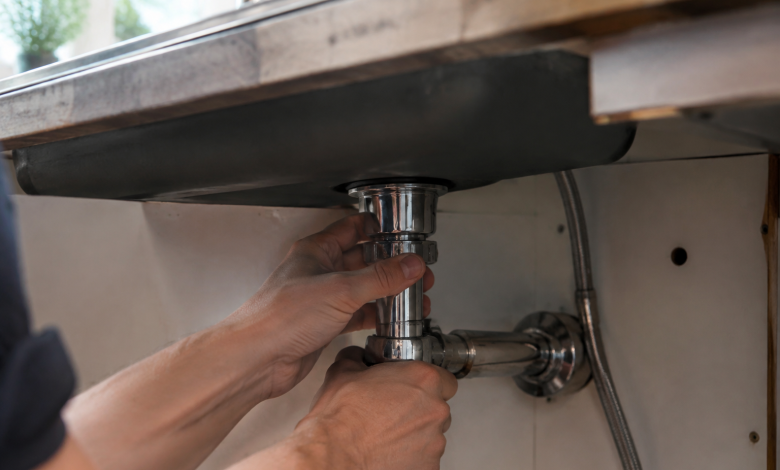 Mains serrant ecrou chrome sous plan travail evier
