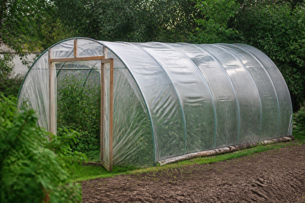 Structure arquee recouverte de plastique transparent au jardin