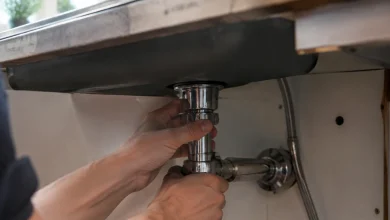 Mains serrant ecrou chrome sous plan travail evier