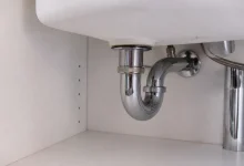Tuyau courbe metalique raccorde sous evier blanc